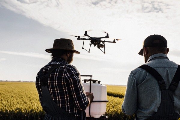 Farmers operating drone in field (ID#5)