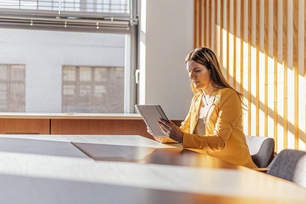 Woman using tablet in sunlit modern office (ID#5)