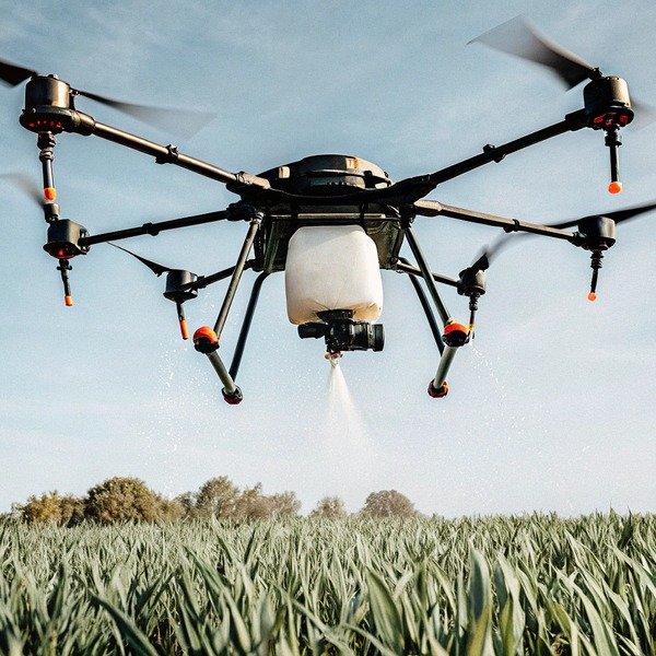 Landwirtschaftliche Drohne beim Sprühen von Pflanzen auf einem Feld (ID#1)