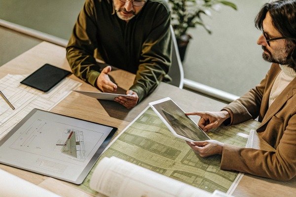Two men reviewing maps and tablet indoors (ID#5)