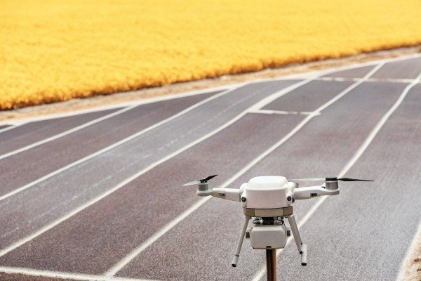 White drone flying over track field (ID#2)