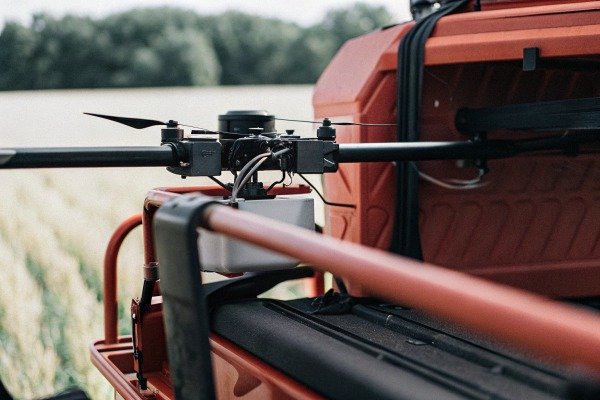 Drone mounted on red vehicle in field (ID#4)