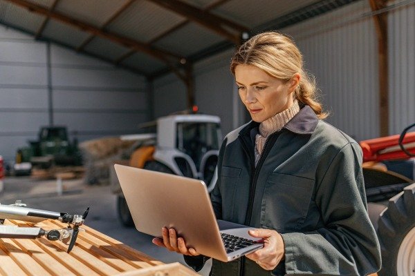 Woman using laptop in warehouse with drone (ID#5)