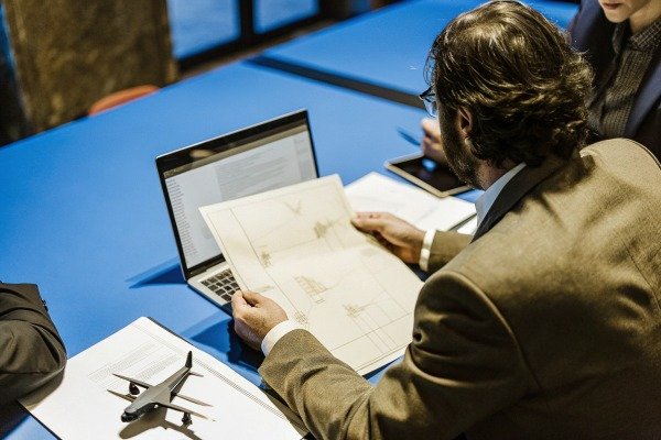 Man reviewing drone plans at meeting table (ID#5)