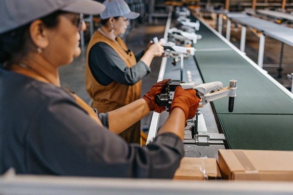 Workers assembling drones on production line (ID#3)