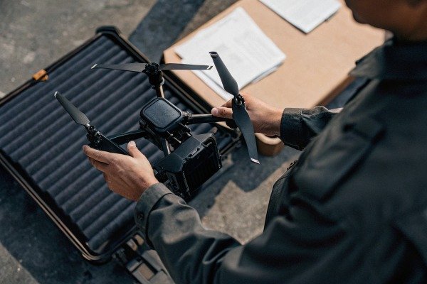 Person holding drone over case (ID#3)