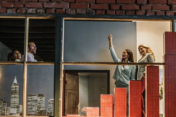 Team celebrating success near window with city view (ID#3)