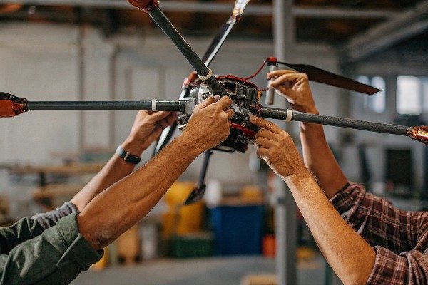 Hands repairing drone propellers in workshop (ID#4)