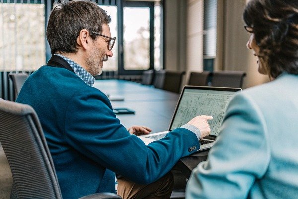 Business meeting with man showing data on laptop (ID#4)