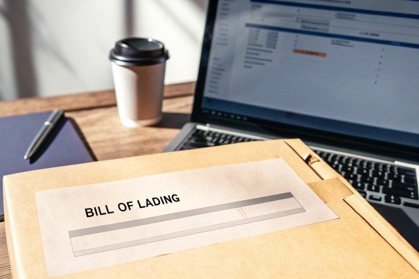 Bill of lading document on desk with laptop (ID#3)
