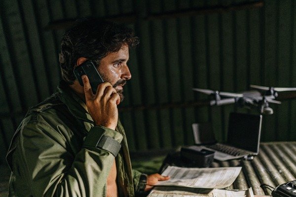 Man talking on phone near drone and documents (ID#3)