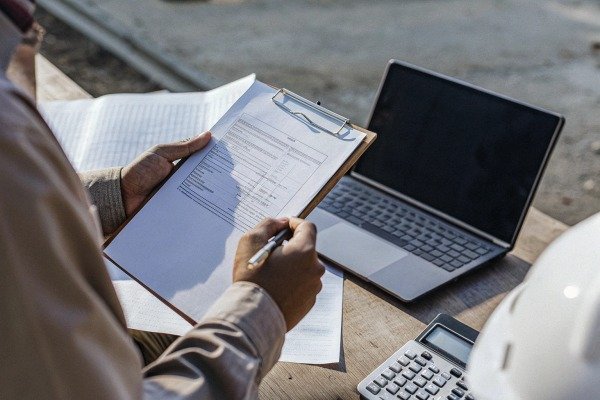 Person filling form with laptop and calculator (ID#3)