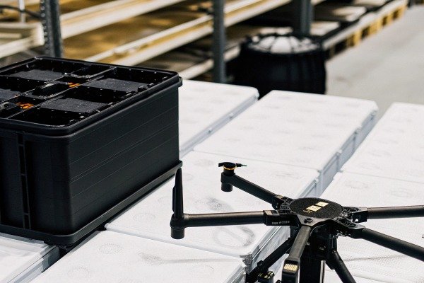 Professional drone sitting on white transport cases next to a black storage container (ID#5)