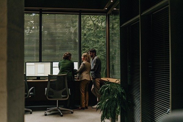 Professional team discussing data on a computer screen in a modern office environment (ID#5)