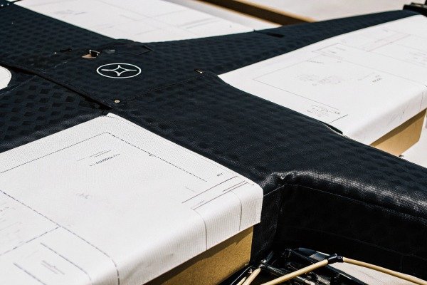 Close-up of a drone wing featuring technical design blueprints and logo (ID#2)