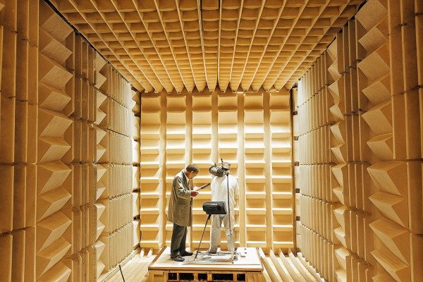 Technicians conducting acoustic testing inside a specialized soundproof anechoic chamber facility (ID#4)