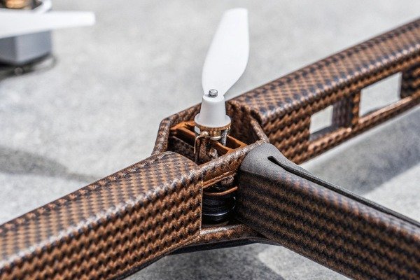 Close-up view of a drone motor and propeller mounted on a carbon fiber arm (ID#4)