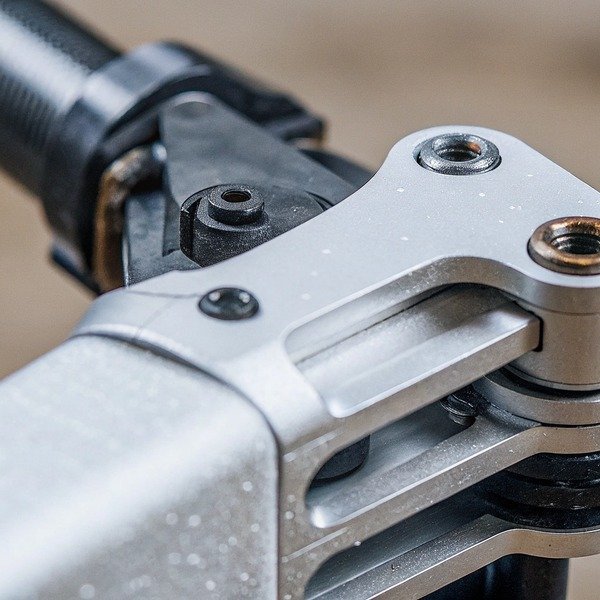 Close-up of a precision-engineered metal drone arm joint with mounting screws (ID#1)