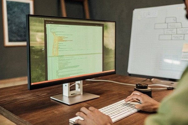 Developer writing software code on a large monitor for drone flight control systems (ID#3)