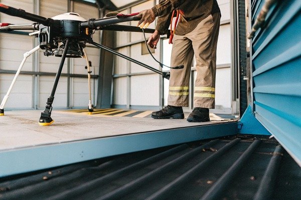 Large industrial drone on a landing platform with a technician nearby (ID#2)