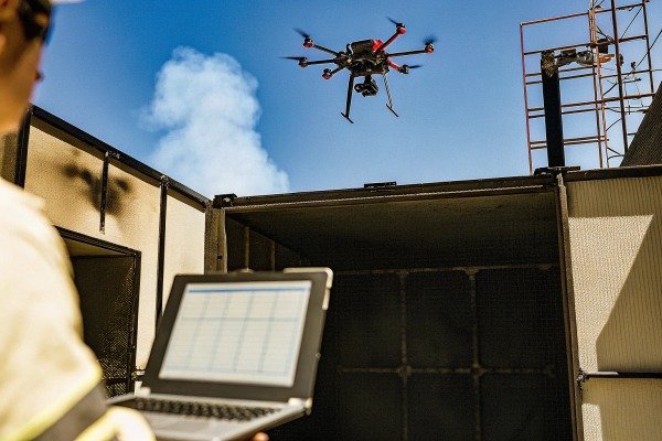 Professional drone pilot monitoring flight data on a laptop during outdoor operation (ID#4)