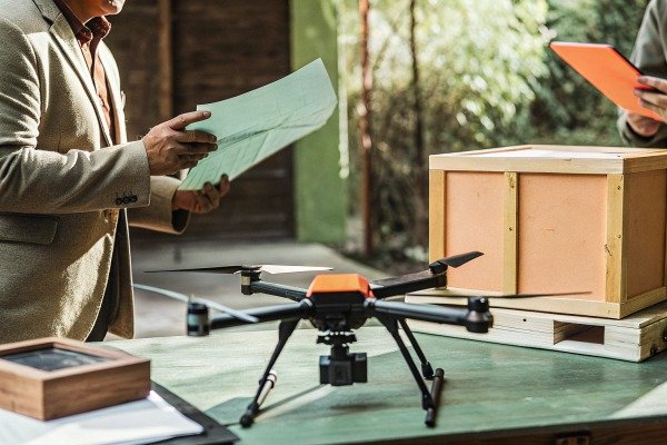 Industrial drone prepared for shipping next to wooden crates and logistics paperwork (ID#5)