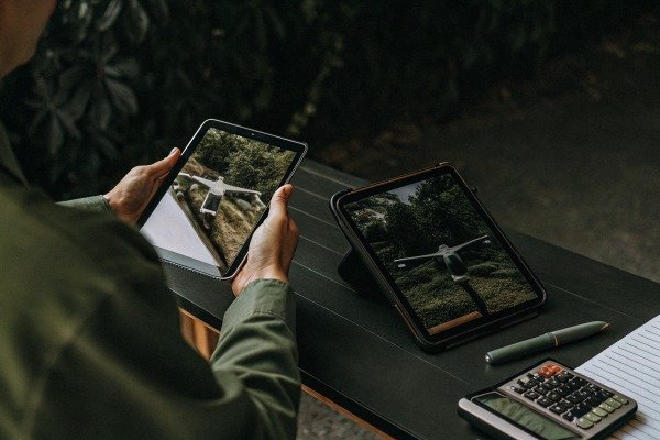 Person reviewing drone captured images on two tablets at a desk (ID#5)