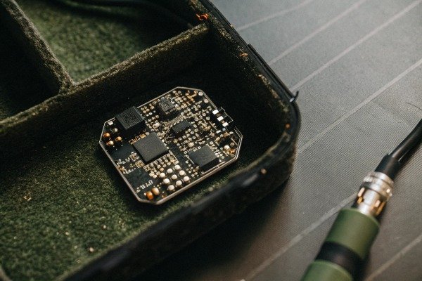 Drone pilot operating a quadcopter in an open field during a sunset (ID#5)