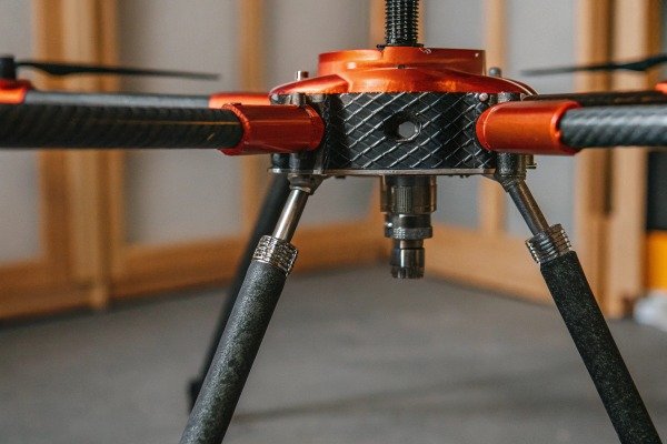 Modern quadcopter drone landing on a dedicated landing pad in a park (ID#5)