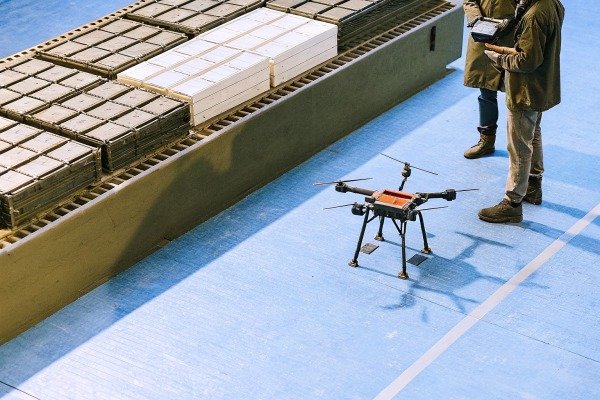 طيار طائرة بدون طيار يشغل طائرة رباعية المروحية في حقل مفتوح أثناء غروب الشمس (ID#4)