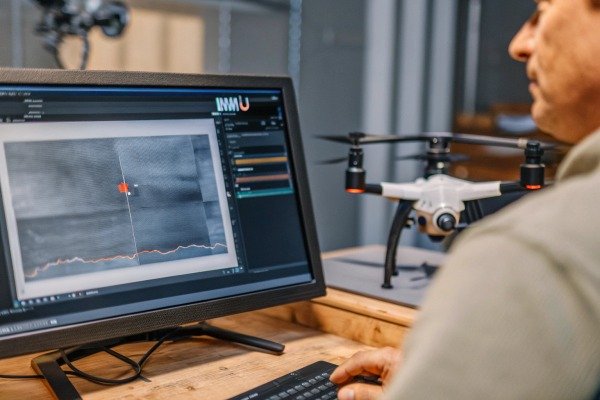 Drone pilot operating a drone using a professional transmitter in a field (ID#5)