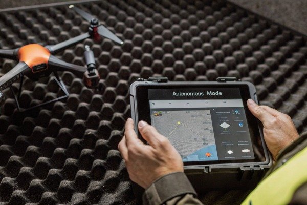 Drone landing on a portable landing pad in a grassy field (ID#5)