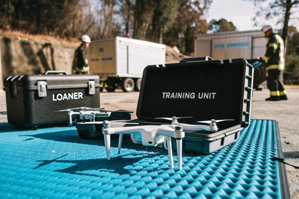 Drone pilot using a remote controller to navigate a quadcopter outdoors (ID#4)