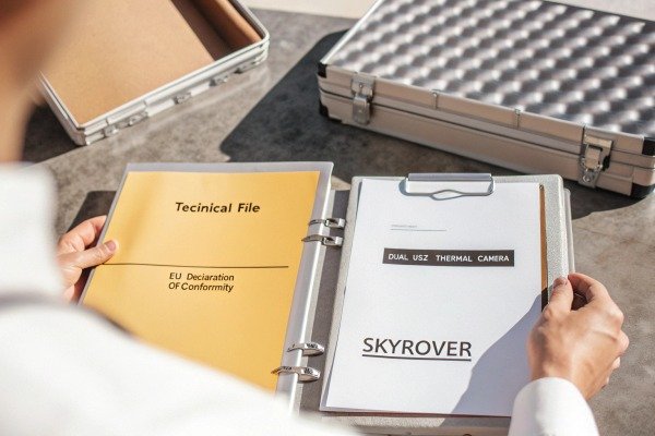 Drone pilot operating a flight using a handheld transmitter in an open field (ID#4)